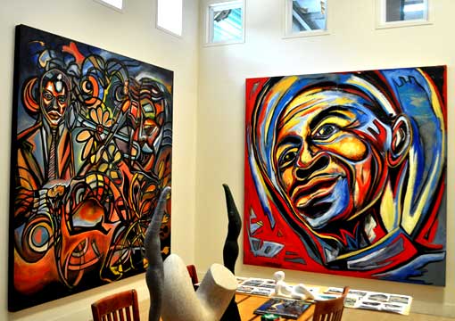 Two large Corey Barksdale canvases installed on a gallery wall beside a sculpture and printed materials