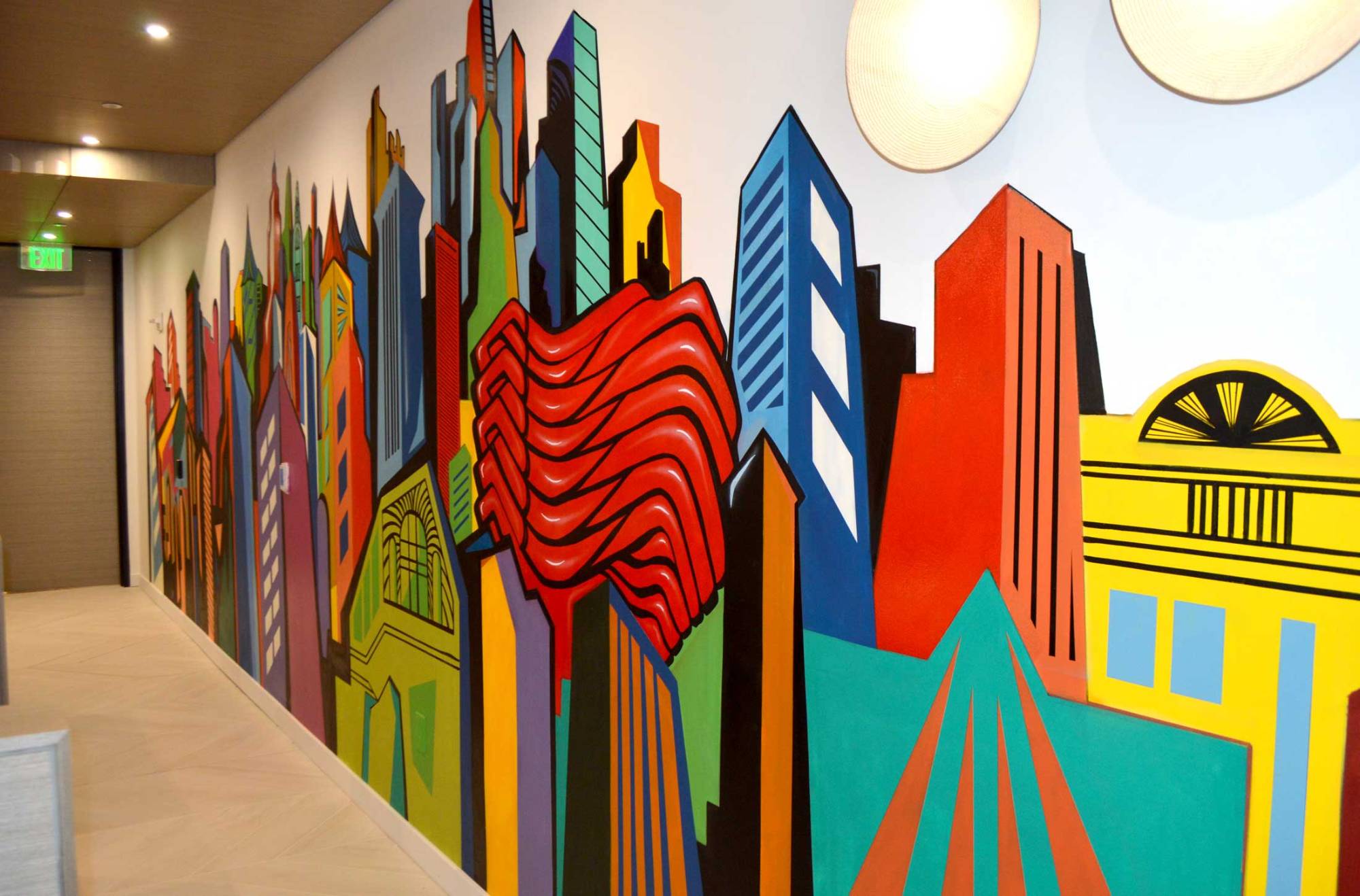 Interior corridor mural of a bold graphic city skyline with a red ribbon form, painted by Corey Barksdale